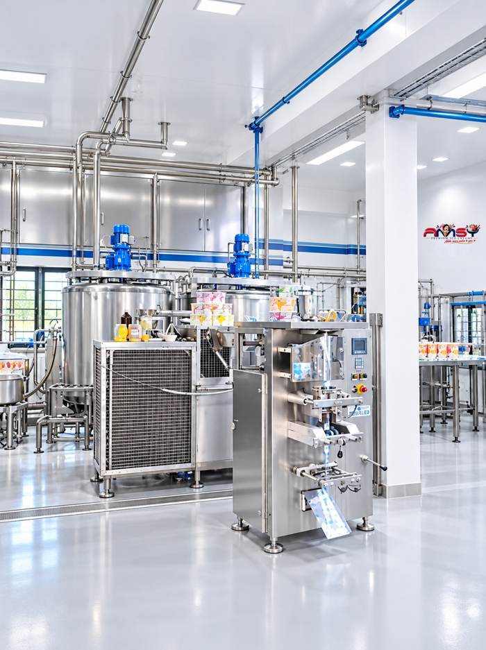 Stainless steel tanks and a packing machine in a bright AMSY production hall